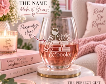 Könnte beinhalten: Ein klares, stieloses Weinglas mit einer weißen Gravur, die ein Weinglas auf einem Bücherstapel zeigt, wobei der Name Kayla auf dem Buchrücken und der Text wine & books darunter steht. Das Glas steht auf einem runden, weißen Marmoruntersetzer.