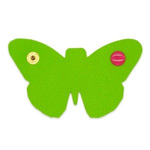 May include: A green felt butterfly with gold and red button accents. The butterfly is a decorative embellishment for crafts and sewing projects.