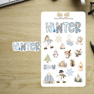 May include: A sticker sheet featuring winter-themed illustrations including the text Twice As Nice Lettering, the word WINTER with a thermometer, a snowman, snowflake, mittens, scarf, penguin, hot cocoa, bird, tree, house, pinecone, candle, and lantern.
