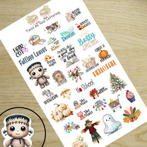 May include: A sheet of planner stickers with various designs and text. The stickers include illustrations of a Frankenstein's monster, pumpkins, a Christmas tree, and phrases like "Hello Fall" and "I'm not bossy."