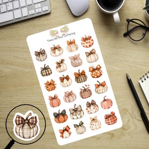 May include: A sheet of fall-themed stickers featuring watercolor pumpkins with bows. The pumpkins have various patterns, including plaid, polka dots, and floral designs. The text "Twice As Nice Lettering" is at the top of the sheet.