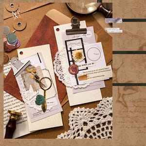 May include: A vintage-themed scrapbook layout with various elements. Includes paper ephemera, dried flowers, a magnifying glass, a wax seal, and decorative paper clips. The color palette is warm, featuring browns, creams, and touches of gold.