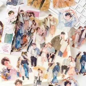 Könnte beinhalten: Eine Sammlung von Aufklebern mit Aquarellillustrationen von Paaren in verschiedenen Posen. Die Aufkleber zeigen Personen, die Blumen halten, Kaffee trinken und sich umarmen. Die Aufkleber sind auf einer weißen Tastatur verstreut.