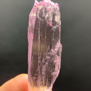 Pu&ograve; includere: Un cristallo rosa traslucido con una punta appuntita e una superficie liscia e lucida.