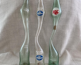 Set mit 3 geschwungenen Limonadenflaschen (Diet Coke, Dr Pepper, RC Cola) | Werbeflaschen aus gestrecktem Glas – Retro-Bar-Dekor