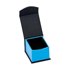 Op de afbeelding: Een kleine, blauwe ringdoos met een zwart interieur. Het deksel is open en de doos is leeg.