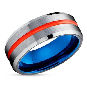 May include: A silver tungsten carbide ring with a red stripe and a blue inner band.