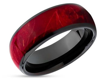 May include: A black tungsten carbide ring with a red wood inlay. The ring has a polished finish and a comfortable fit.