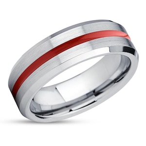 Puede incluir: Un anillo de carburo de tungsteno plateado con una franja roja alrededor de la banda.