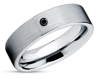 May include: A brushed silver band with a single black diamond set in the center.