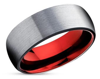 May include: A brushed silver wedding band with a red inner band. The ring is made of tungsten carbide.