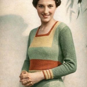 May include: A vintage-style green dress with long sleeves, featuring a square neckline and a horizontal orange stripe across the midsection. The dress has yellow and orange accents on the neckline and cuffs. The woman is smiling.