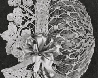 May include: A vintage, off-white lace bonnet with a delicate, openwork design. The bonnet features a large, decorative bow made of satin ribbon and intricate floral lace detailing along the edges. The overall style is reminiscent of antique baby bonnets.