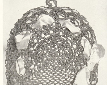 May include: A dark brown crocheted tea cozy with a circular design and a looped handle. The cozy is adorned with several satin bows in a light cream color, adding a touch of elegance to the handmade item. The open weave allows the color of the tea pot to show through.