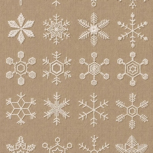 May include: A collection of sixteen white embroidered snowflakes on a tan fabric background. The snowflakes vary in design, showcasing intricate details and symmetrical patterns. Ideal for winter-themed crafts or decor.