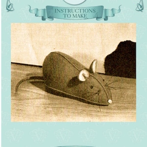 May include: Vintage Visage sewing pattern featuring instructions to make a stuffed mouse. The mouse is brown with white ears and whiskers. The background is a light sepia tone with decorative borders and text.
