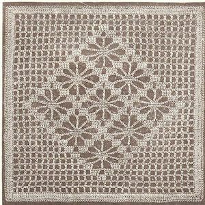 May include: A square, off-white crocheted doily with a detailed floral pattern in the center. The design features a grid-like border and a series of floral motifs. The piece is likely handmade and suitable for home decor.