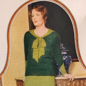 Könnte beinhalten: Vintage-Bild einer Frau in einem grünen Pullover mit einem limettengrünen Schleifendesign. Der Pullover hat lange Ärmel und eine kontrastierende limettengrüne Bordüre. Die Frau trägt einen hellgrünen Rock und eine Perlenkette.