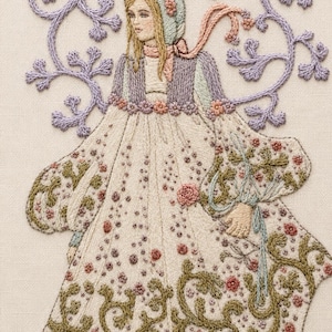 May include: Embroidered artwork of a woman in a long dress and bonnet, featuring floral and vine details. The dress is cream-colored with scattered red and brown floral accents. The bonnet and jacket are light blue and lavender, with a pink scarf.