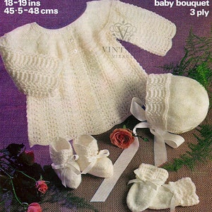 May include: A cream-colored baby outfit set, including a sweater, bonnet, and booties. The set is knit with a delicate pattern and features ribbon accents. The sweater measures 18-19 inches (45.5-48 cm). The text "baby bouquet 3 ply" is visible.