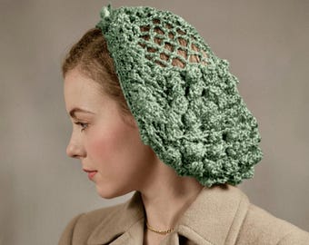 May include: A sage green crocheted head covering with a textured, raised pattern and open netting. The head covering is worn on the head and is made of a soft, possibly wool, yarn. The style is vintage and elegant.