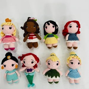 May include: Eight crocheted dolls, each representing a different Disney princess. The dolls are all wearing different dresses and have different hair colors and styles.