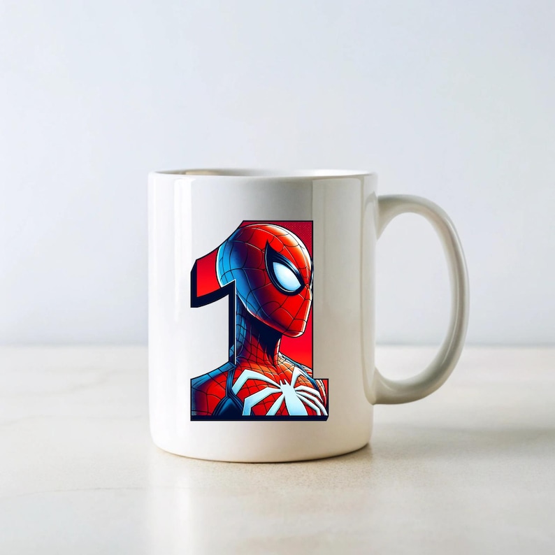Pu&ograve; includere: Tazza in ceramica bianca con un'illustrazione di Spiderman rossa e blu e il numero "1" stampato su di essa.