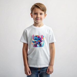 May include: White t-shirt featuring a blue cartoon character wearing a red and pink jacket and a blue hat, roller skating on a colourful background.