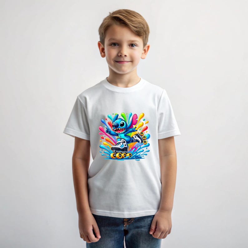 May include: White t-shirt featuring a blue cartoon character on roller skates, surrounded by colourful paint splatters.