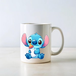 以下が含まれることがあります： 白いセラミックマグカップ。映画「リロ＆スティッチ」のスティッチの漫画イラストが描かれています。青いエイリアンがオレンジ色の乳首が付いた哺乳瓶を持っています。マグカップには白いハンドルがあり、白い背景に置かれています。