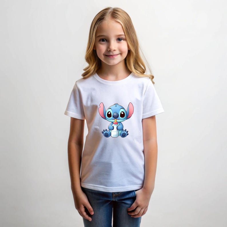 以下が含まれることがあります： 白いTシャツには、青い宇宙人キャラクターであるスティッチが哺乳瓶を持っている漫画のイラストが描かれています。 このTシャツは、金髪の女の子と青いジーンズが着用しています。