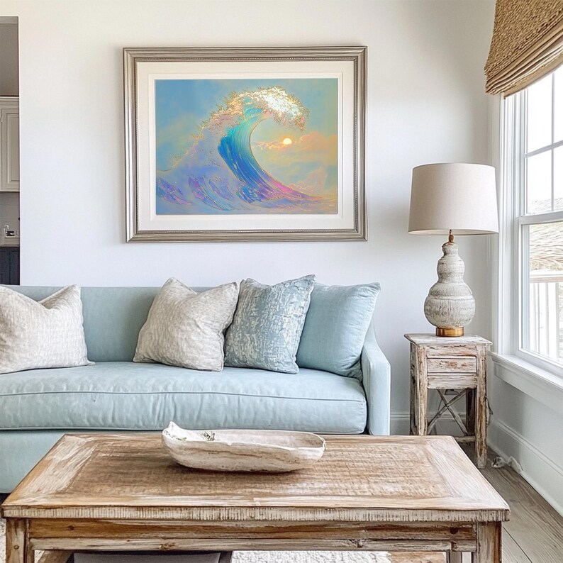 Puede incluir: Un sof&aacute; azul claro con tres almohadas, una mesa de caf&eacute; de madera con un taz&oacute;n decorativo, una l&aacute;mpara sobre una mesa auxiliar de madera y una pintura enmarcada de una ola con una puesta de sol en el fondo.