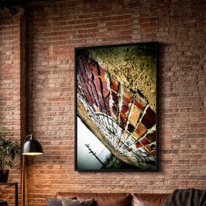 a cozy living room with a brick wall, a large window overlooking a city skyline, and a brown leather couch. A wooden coffee table sits in front of the couch, and a framed artwork of a colorful butterfly is hanging on the wall above it.