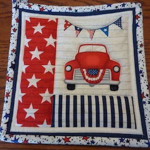 May include: Red, white, and blue patriotic themed hot pad with a red truck, stars, and bunting.