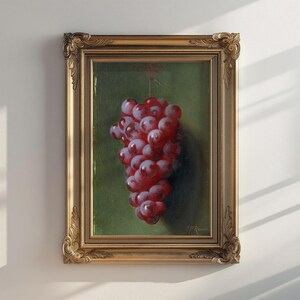 Peut inclure: Peinture encadrée d'une grappe de raisins rouges. Les raisins sont suspendus sur un fond vert. Le cadre est doré avec des détails ornés. La peinture est signée en bas à droite.
