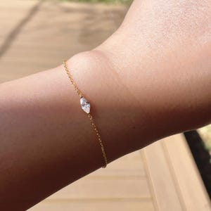 Pu&ograve; includere: Un delicato braccialetto d'oro con un diamante taglio marquise. Il diamante &egrave; il punto focale, incastonato in un design semplice ed elegante. Il braccialetto &egrave; indossato su un polso, mettendo in risalto la sua sottile brillantezza e la sua estetica raffinata.