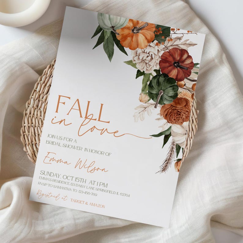 May include: A white invitation card with the text "FALL in love" in brown script, decorated with watercolor pumpkins and floral elements. The card is for a bridal shower in honor of Emma Wilson.