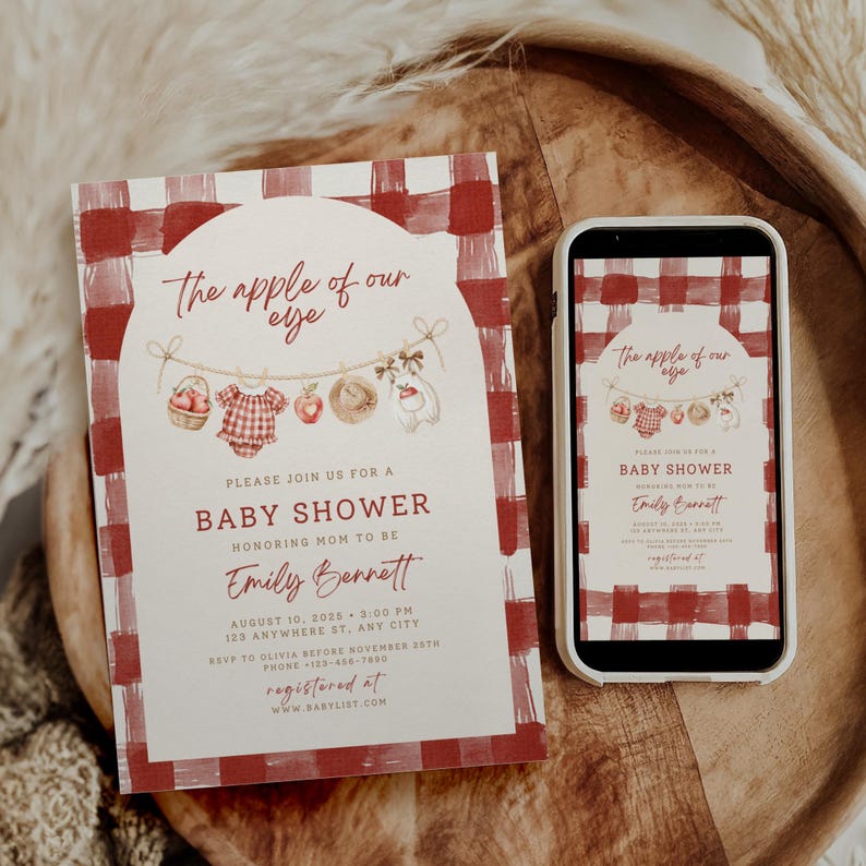 Pu&ograve; includere: Un invito rettangolare per baby shower e uno smartphone che mostra lo stesso design, entrambi con un bordo a quadri rossi e bianchi, una cornice ad arco e un'illustrazione di un filo da bucato con un cesto di mele, un vestito e una mela.