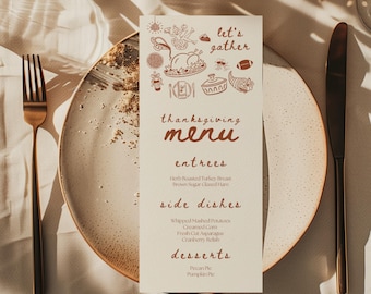 May include: A Thanksgiving menu card with illustrations and text, placed on a plate with a fork and knife. The menu includes entrees, side dishes, and desserts. The card reads "Let's Gather" at the top.