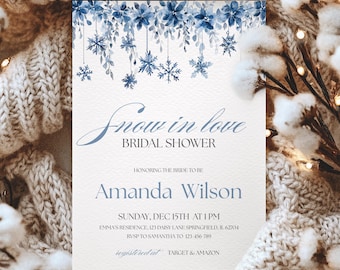 May include: A bridal shower invitation with a winter theme. The invitation features blue watercolor snowflakes and floral accents. The text reads "Snow in love, Bridal Shower" and includes the bride's name, date, and time.