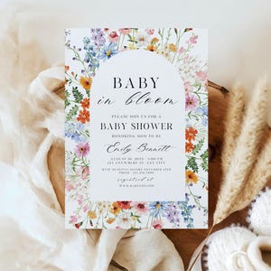Puede incluir: Invitaci&oacute;n a baby shower con borde floral. La invitaci&oacute;n presenta el texto "BABY in bloom" en una escritura elegante. La invitaci&oacute;n incluye detalles del evento, como la fecha, la hora y el lugar, y el nombre "Emily Bennett".
