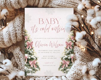 May include: A baby shower invitation with the text "BABY it's cold outsia" in pink script. The invitation features Christmas trees with pink bows and snowflakes. The invitation is on a light pink background.
