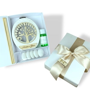 Può includere: Un set di scatole regalo bianche con un design ad albero della vita, una bottiglia di liquido verde e caramelle bianche. La scatola è legata con un nastro e un fiocco dorati. Include bastoncini di legno per diffusore.