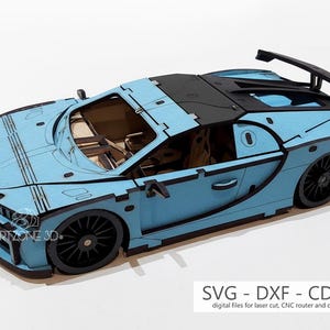 Könnte beinhalten: Ein hellblaues Holzmodellauto mit schwarzen Akzenten, einschließlich Rädern und Heckspoiler. Das Auto hat ein detailliertes Design und der Text "ARTZONE 3D" ist sichtbar. Der Text "SVG - DXF - CDR - AI" ist ebenfalls vorhanden.
