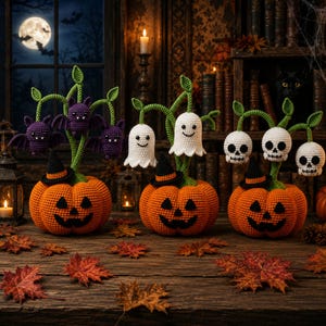Puede incluir: Tres calabazas naranjas de ganchillo con caras de jack-o'-lantern negras y pequeños sombreros de bruja negros. Cada calabaza tiene tallos verdes con tres figuras de ganchillo: murciélagos morados, fantasmas blancos y calaveras blancas.