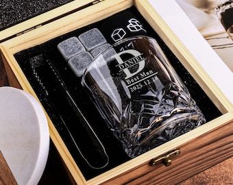 Puede incluir: Un juego de caja de regalo de madera que contiene un vaso de whisky personalizado, piedras de hielo, pinzas y un posavasos. El vaso está grabado con "DANIEL Best Man 2025.12.28". El posavasos es mitad madera y mitad blanco.