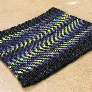 May include: A black knit headband with a wavy pattern in shades of purple, blue, and yellow.