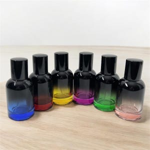 May include: Seven glass bottles with black caps and a gradient of color from black to blue, red, yellow, purple, green, and pink.
