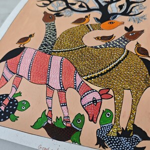 May include: A colorful Gond art painting featuring stylized animals and birds under a tree. The animals have patterned bodies in red, yellow, and black. Small green turtles are at the bottom. The background is a light peach color.