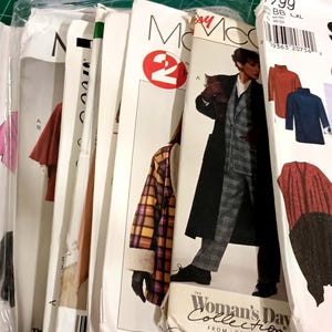 May include: A collection of assorted sewing patterns from brands including Simplicity and McCall's. The paper envelopes feature illustrations of various garments such as coats, ponchos, and skirts, with printed text including 2 HOUR and Woman's Day.